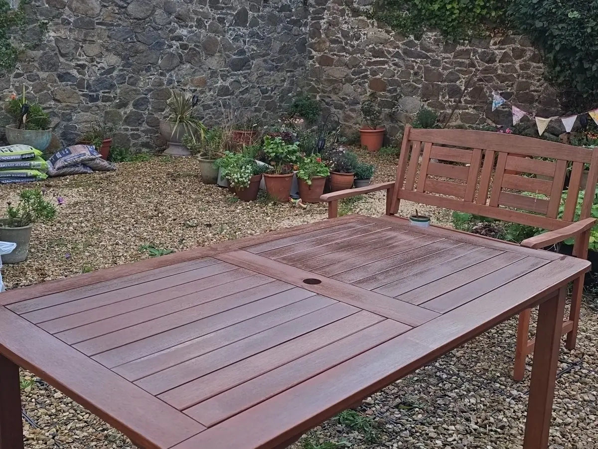 Finished garden patio with stone wall, outdoor furniture and planting in Guernsey